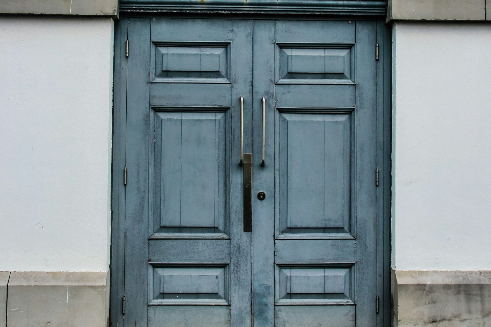 Hand prüft Türscharnier an einer weißen Innentür