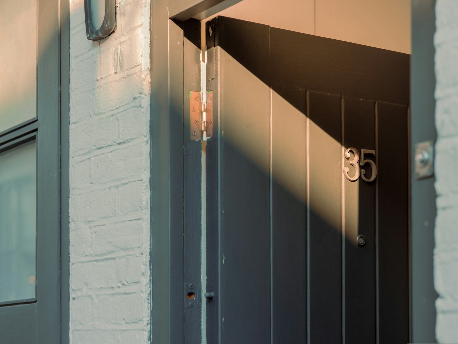 Person prüft Türscharniere an einer geöffneten Innentür